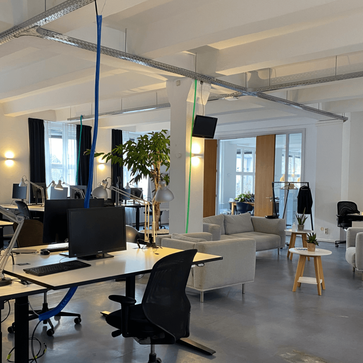 Innenraum vom Büro mit Schreibtischen und Bildschirmen.